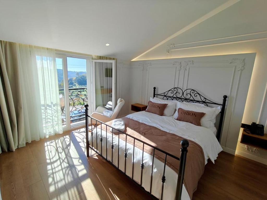 Orion Palace Boutique Hotel في دوريس: غرفة نوم مع سرير كبير وشرفة