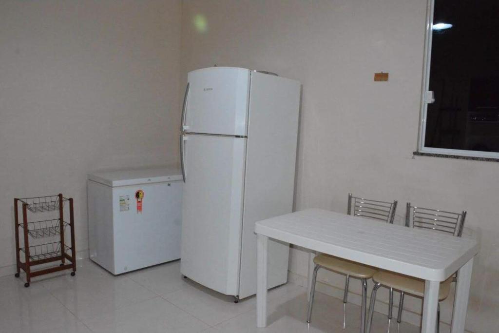 een keuken met een witte koelkast en een tafel bij Sitio Belo Vale in Juiz de Fora