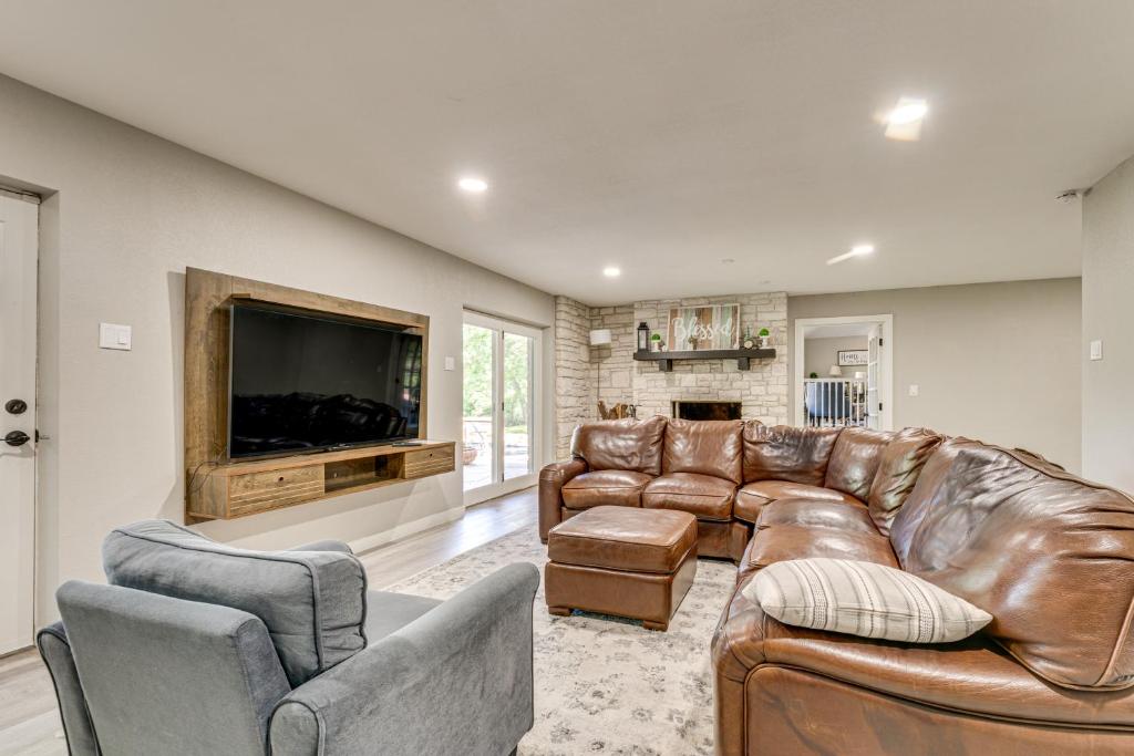 ein Wohnzimmer mit Ledermöbeln und einem Flachbild-TV in der Unterkunft Home Gym, Office and Dock! Seguin Riverfront Retreat in Seguin