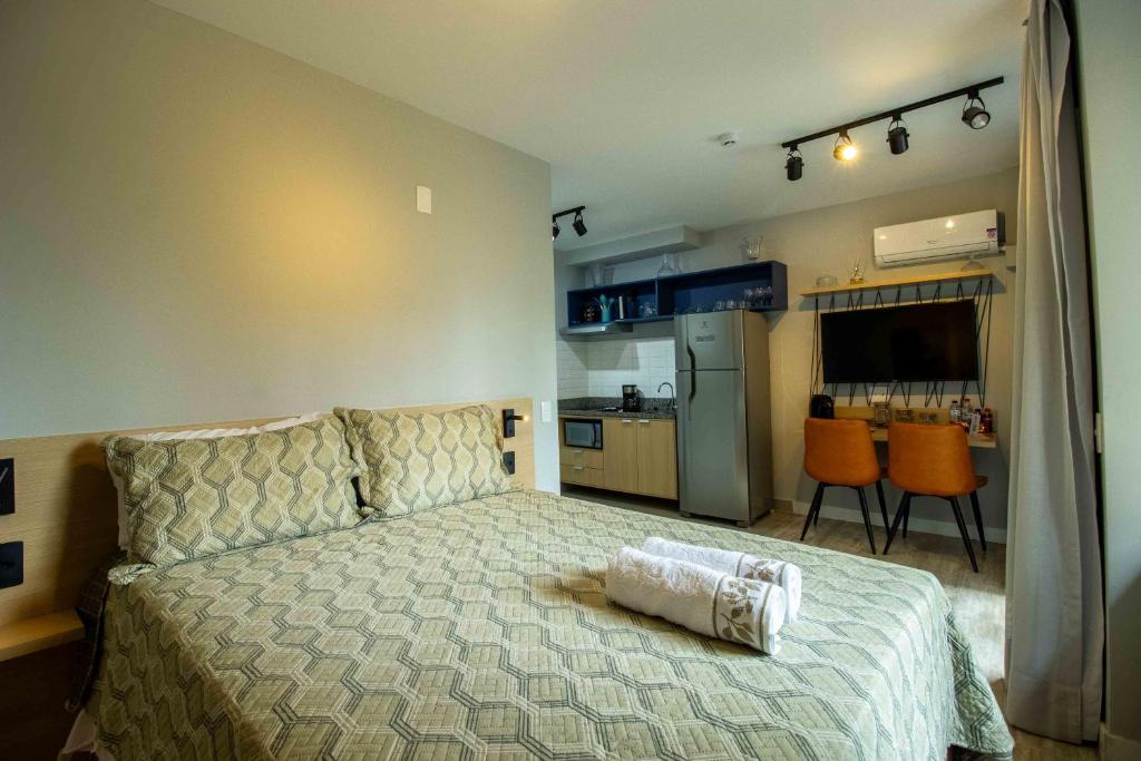 Un dormitorio con una cama grande y una cocina. en Novo studio sofisticado ao lado do Allianz Parque, en São Paulo