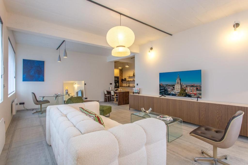 Una sala de estar con un sofá blanco y una mesa. en Loft Urban Chic - Beffroi d'Amiens, en Amiens