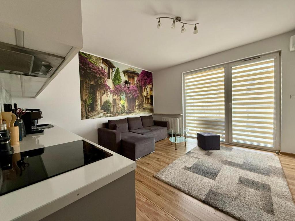 Una cocina y una sala de estar con un sofá. en Modlinska Residence by JumpInHere, en Nowy Dwór Mazowiecki