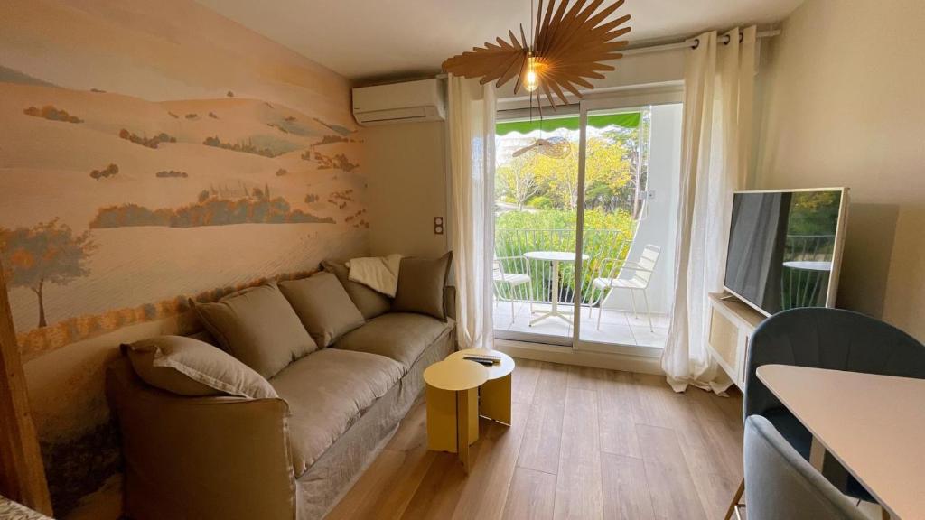 a living room with a couch and a window at Écume et Sérénité Parking Privé Wifi Clim et LIT en 140 in La Grande-Motte
