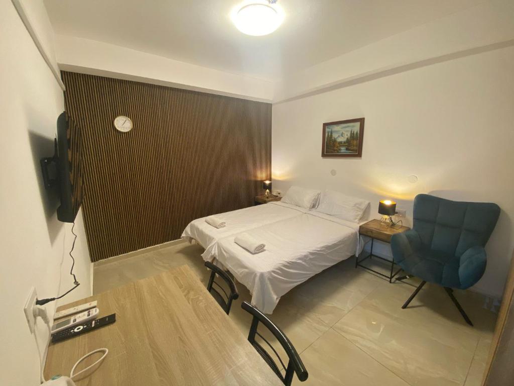 a small room with a bed and a blue chair at יחידת אירוח רחוב נחשון in Kibbutz Nachshon