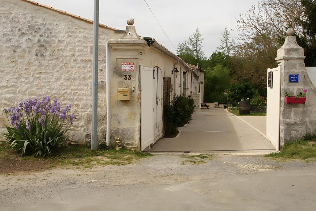 ein altes Gebäude mit Tür und Bürgersteig in der Unterkunft Le Bouquet de Soizic in Grandjean