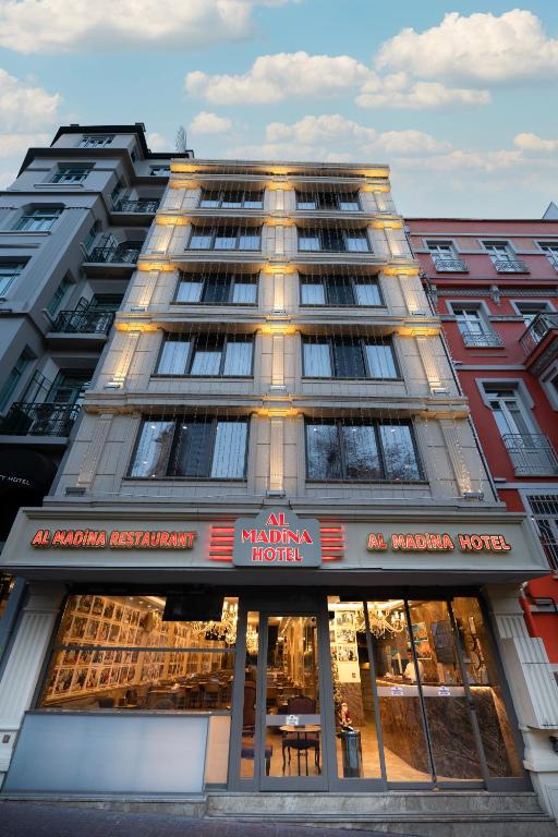 a tall building with a restaurant in front of it at Almadina Hotel Istanbul in Istanbul