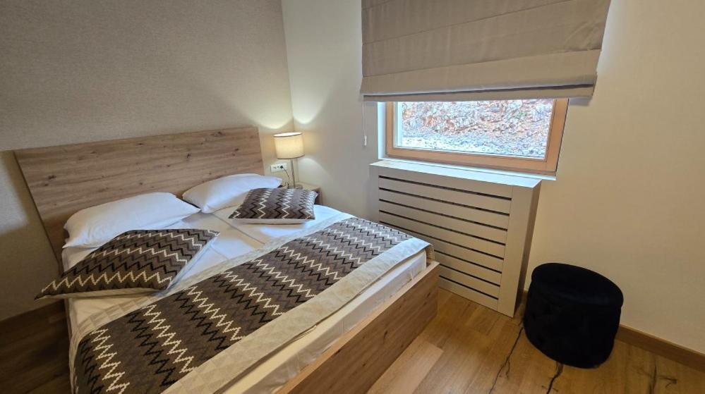 a bedroom with a large bed and a window at Apartman C437 Aparthotel Vucko Jahorina privatni apartman in Jahorina