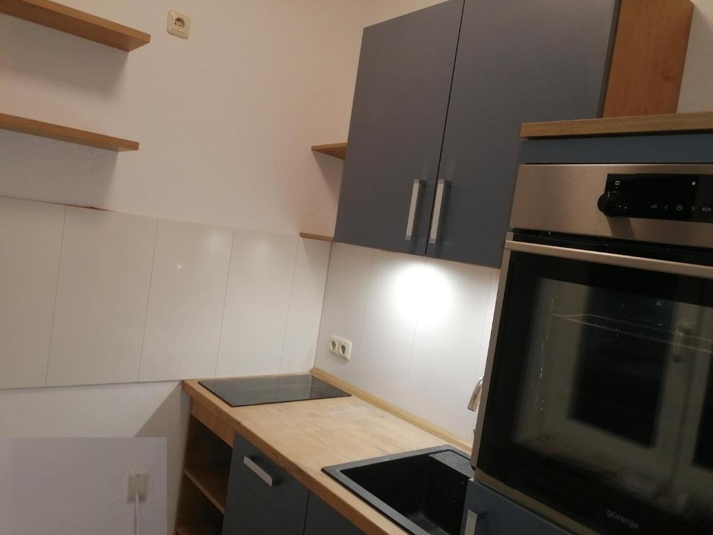 a kitchen with gray cabinets and a stove top oven at Central Apartments Chemnitz KASSBERG in Chemnitz
