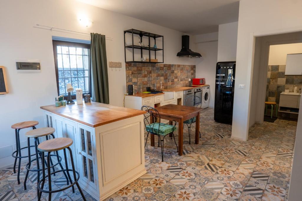 - une cuisine avec un comptoir et quelques tabourets dans l'établissement FIAMBI & b, à Colugna