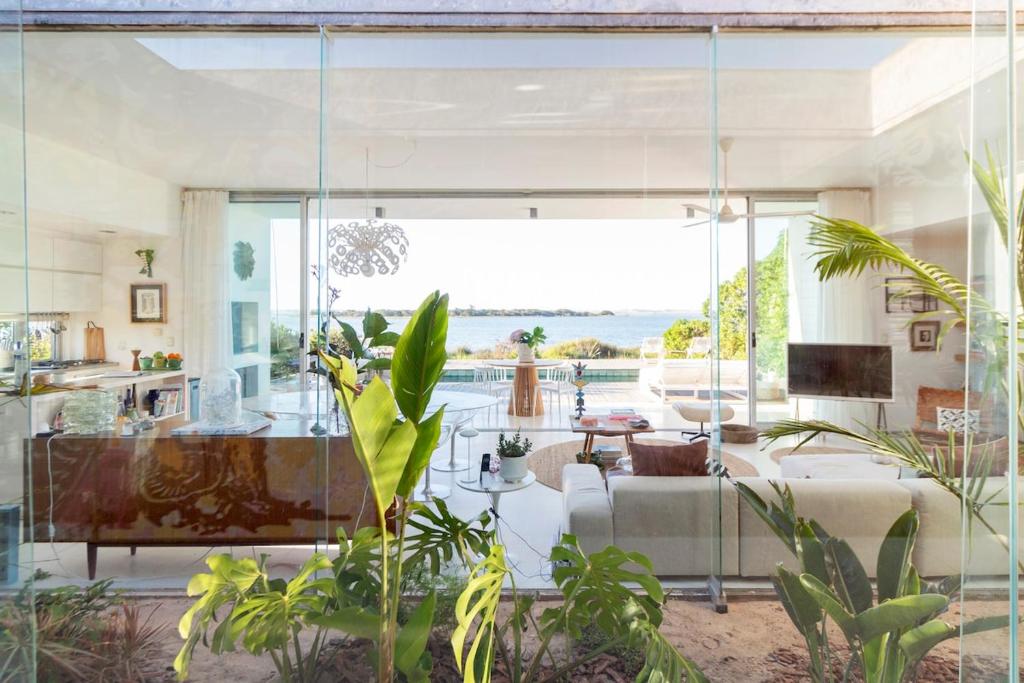 Dream house on Jose Ignacio Lagoon في خوسيه اجناسيو: غرفة معيشة مع جدار زجاجي كبير