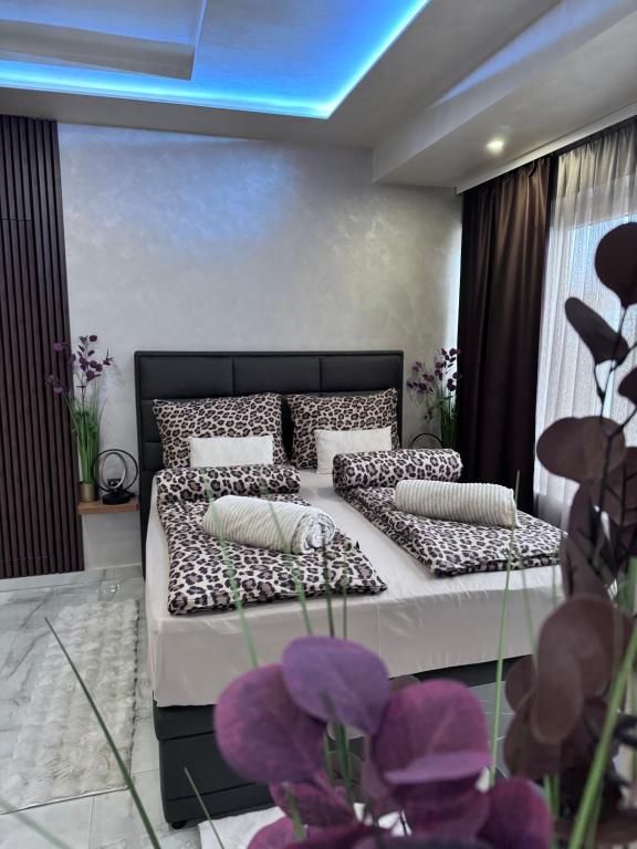 a bedroom with two beds with pillows and purple flowers at Studio apartman Luna in Vinkovci