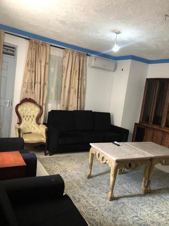 a living room with a black couch and a coffee table at Blue Waves Apartments in Mombasa