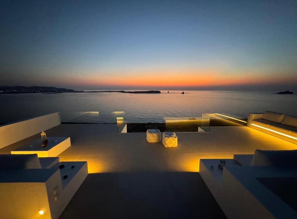 un tramonto sull'acqua con due candele su un ponte di Endless Blue a Sarakíniko