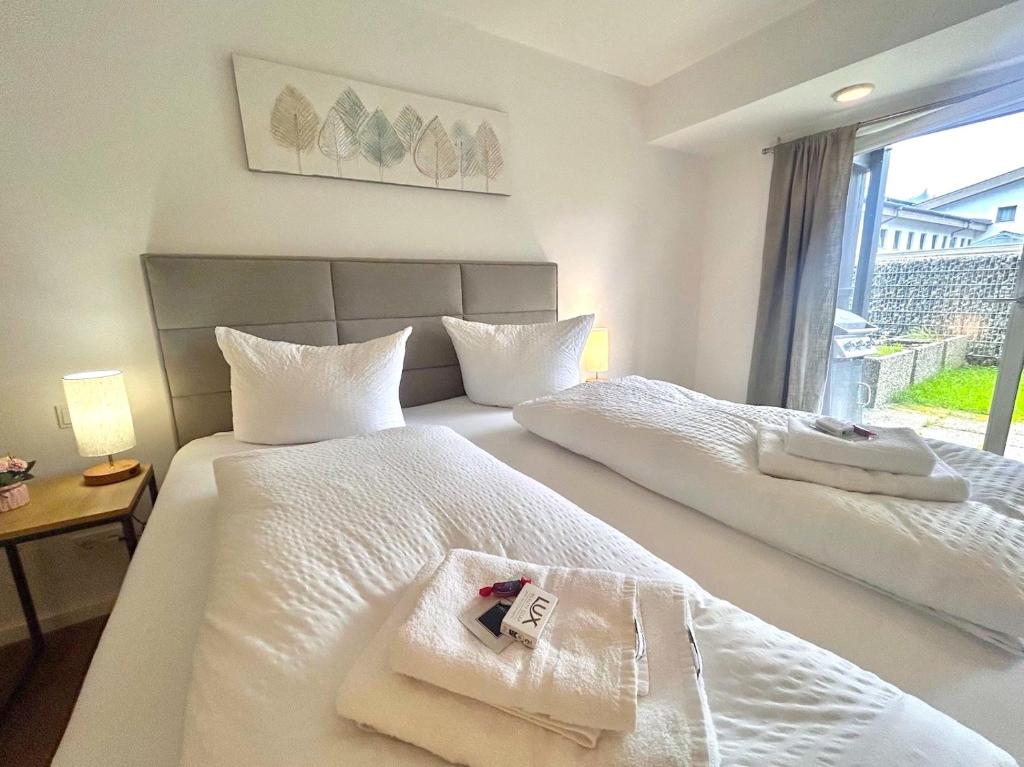 Ferienwohnung "Seeruhe" - Berge, See und Natur am Spitzingsee في شليرزيه: غرفة فندقية بها سريرين مع مناشف عليهما