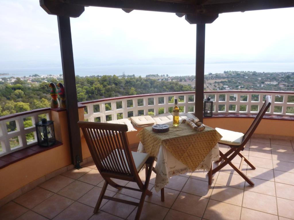 una mesa y sillas en un balcón con vistas en Villa Faidra en Erétria