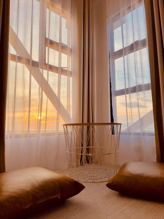 a bedroom with a large window with white curtains at YukiDo Skynest in Mactan Island