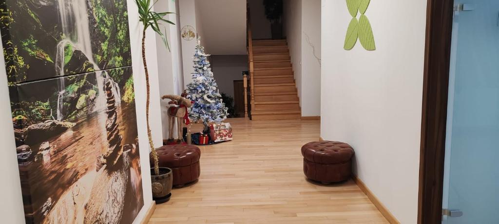 un pasillo con un árbol de Navidad y una escalera en Pensiunea Terra Serenity, en Snagov