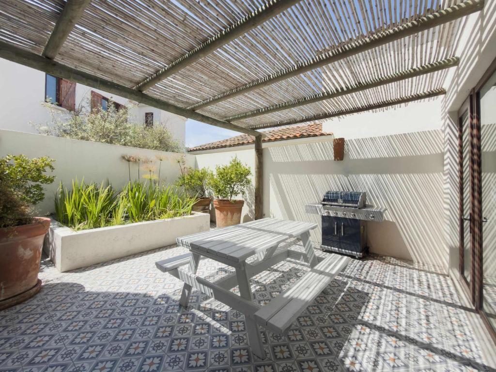 Casapueblo Rent Cachagua CP 34 في Cachagua: فناء مع طاولة نزهة وبرغولا خشبي