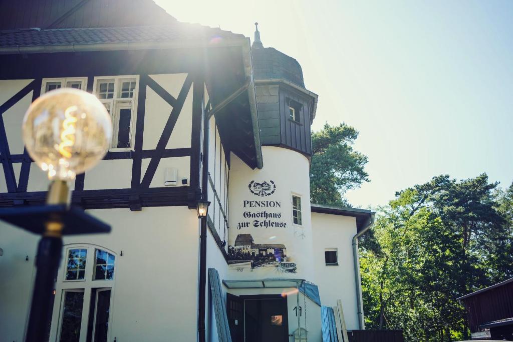 a building with a sign on the side of it at Pension zur Schleuse Kleinmachnow in Kleinmachnow