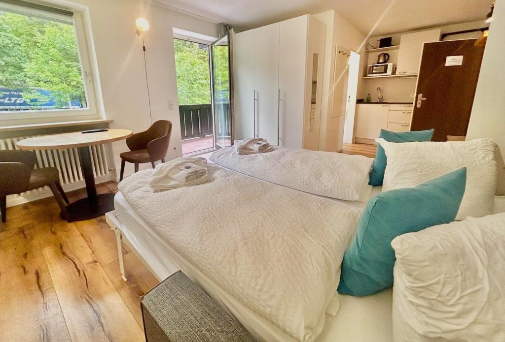 a bedroom with two beds and a table and a window at Ferienwohnung "Seeluft" - Raus in die Berge und an den See in Schliersee