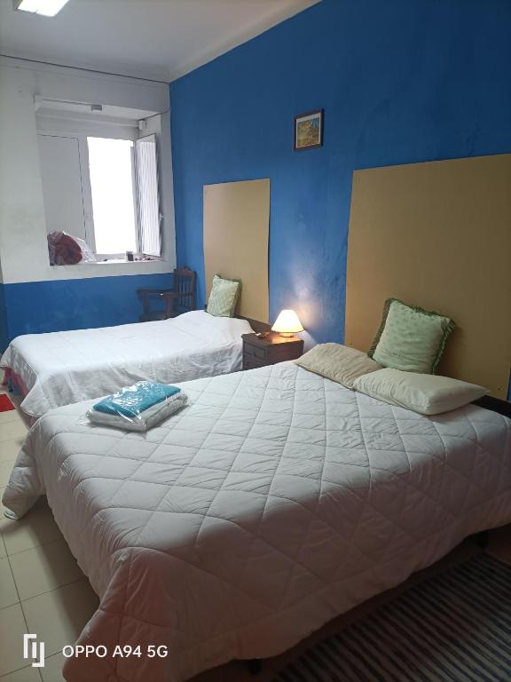 a bedroom with two beds and a blue wall at ViSIT CASTELO BRANCO in Castelo Branco