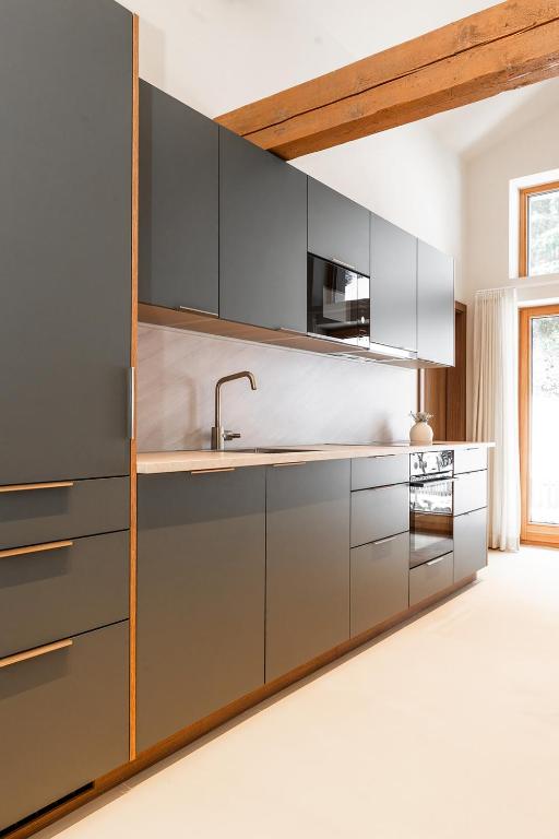 a kitchen with gray cabinets and a sink at Appartements No37 in Hüttschlag
