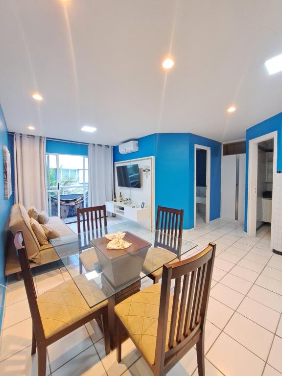 una sala da pranzo con tavolo e sedie in vetro di Flat Blue Ponta Negra Beach a Natal