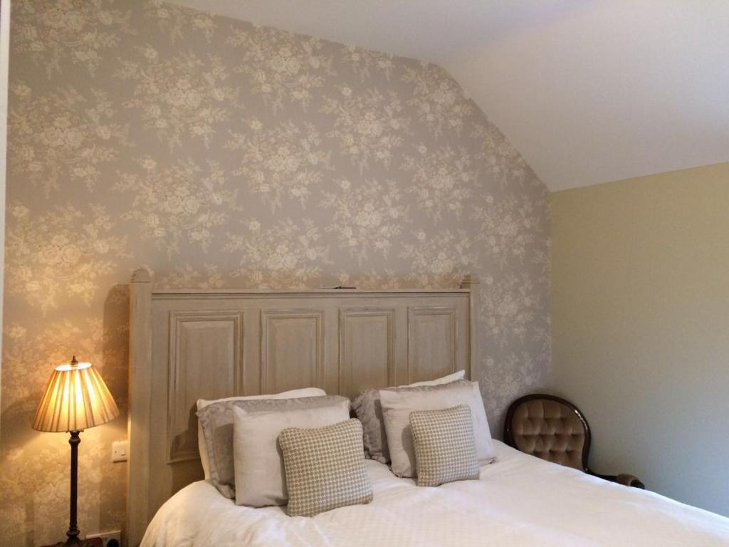 1 dormitorio con 1 cama con almohadas blancas en Riverbank, Country Pub and Guesthouse, en Carrickmacross