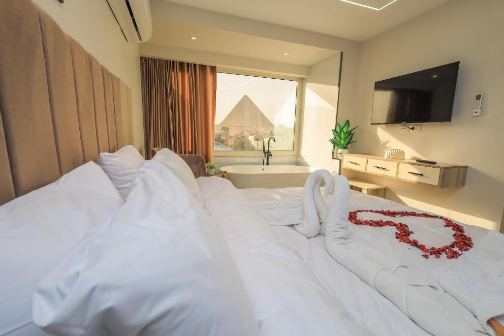 a bedroom with a white bed with a red rose on it at First Site OF Pyramids View & Jacuzzi in Cairo