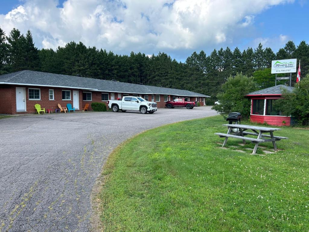 a parking lot with a picnic table and a building at Mountain View Motel in Barrys Bay