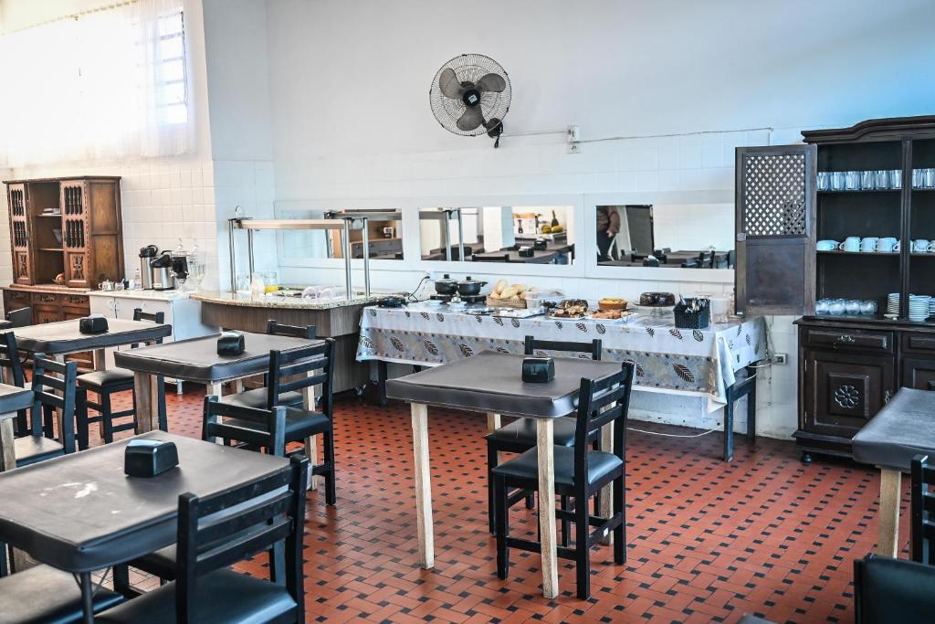 Hotel Bandeirantes de SJBV في ساو جواو دا بوا فيستا: مطعم فيه طاولات وكراسي في مطبخ
