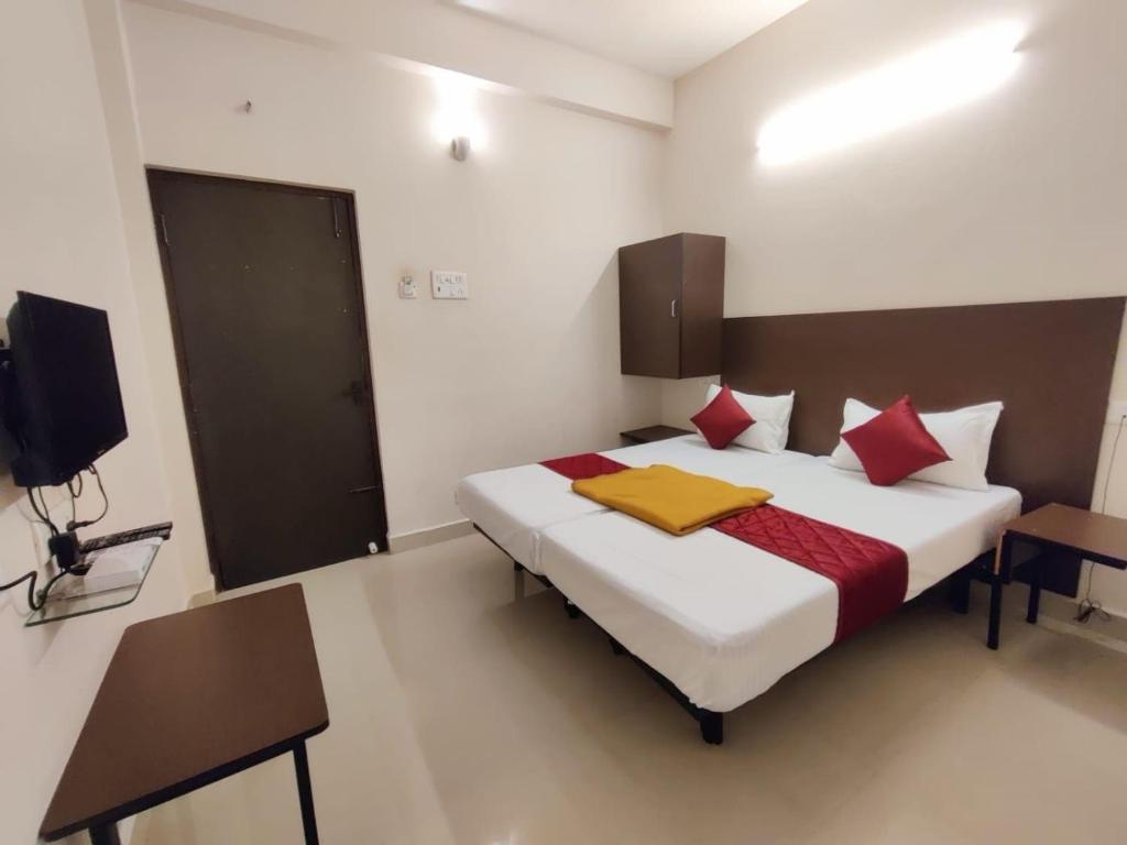 a bedroom with a large bed with red pillows at Super Hotel O Red Moon Residency in Chennai