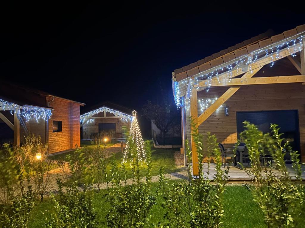 a garden with christmas lights and a house at Les Chalets près de Chalain in Montigny-sur-lʼAin