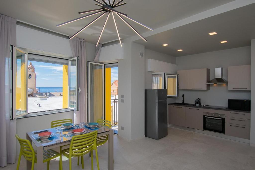 une cuisine et une salle à manger avec une table et des chaises dans l'établissement Varicottis Luxury Apartments con parcheggio privato, à Varigotti