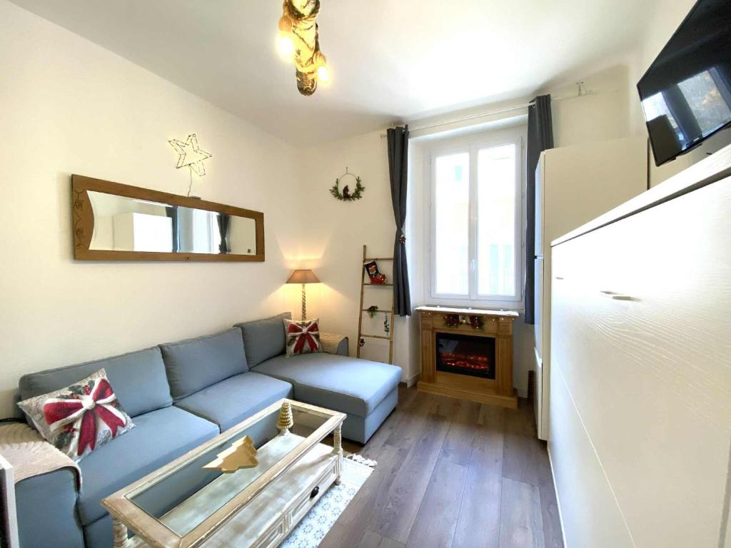 a living room with a blue couch and a fireplace at Studio Bareges Le Rioulet 1 in Barèges