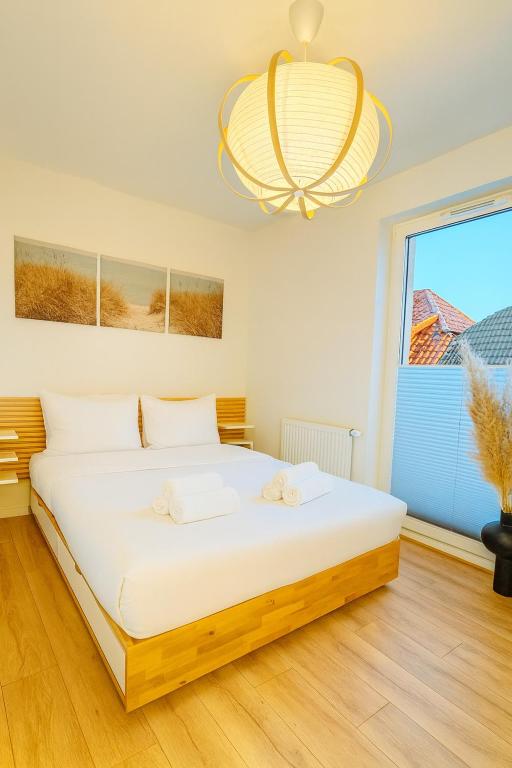 a bedroom with a large bed and a chandelier at Apartament Infinity in Skorka
