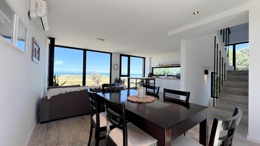 a dining room and living room with a table and chairs at Casa Altamar - Casa Con Vista Al Mar en Playa Cruz del Sur, Chapadmalal Para 6 PAX Con Parrilla y Cochera - Hola Sur in Chapadmalal