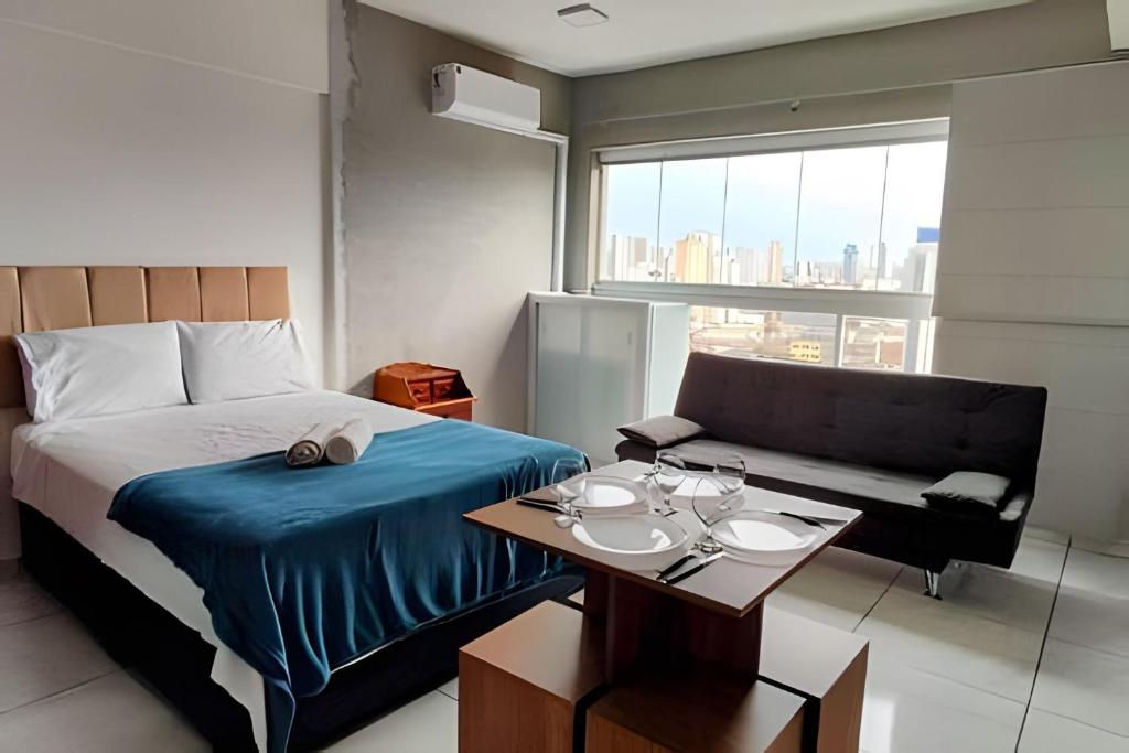 a bedroom with a bed and a table and a couch at Aeroporto Gru, Ar Condicionado, Piscina+Academia in Vila Gopoúva