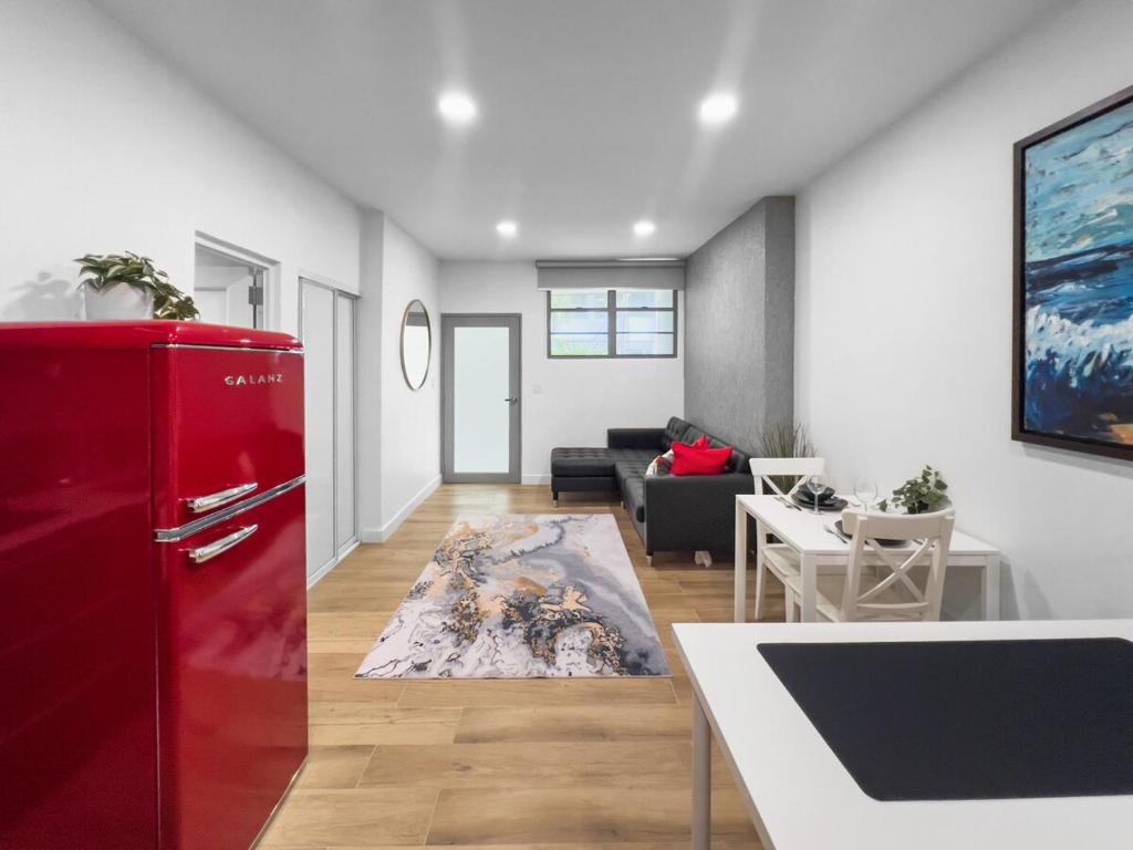 uma cozinha e sala de estar com um frigorífico vermelho em La Rada 015 Studio Apt in San Juan with Pool em San Juan