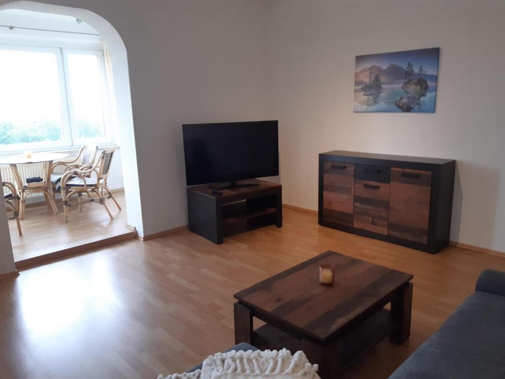 a living room with a tv and a coffee table at Ferienwohnung Fernblick in Bannewitz