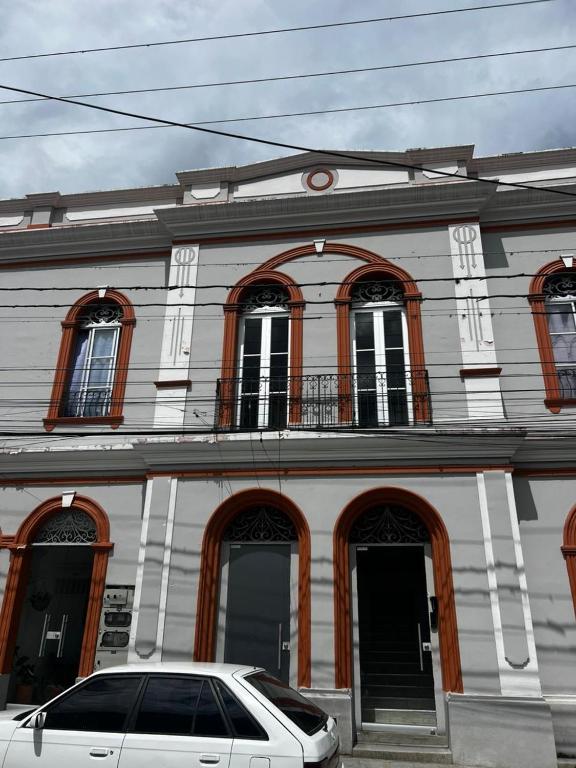 a white car parked in front of a building at Casa-Hostal La Casona in Roldanillo