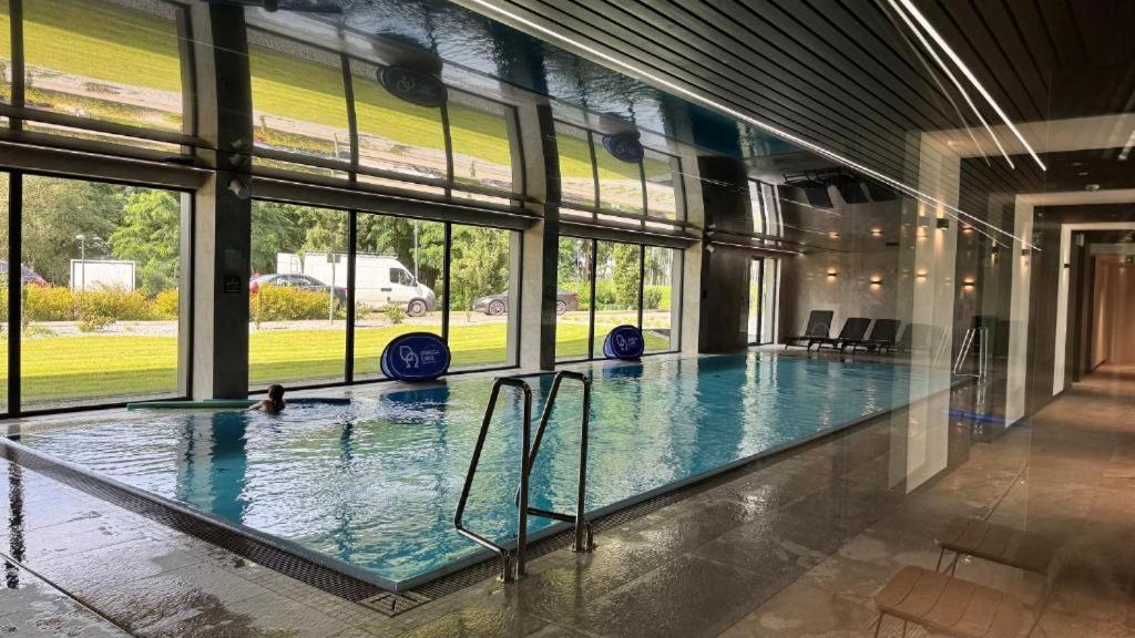 ein großer Innenpool mit einer Person darin in der Unterkunft Omega Lake Family 1 in Olsztyn