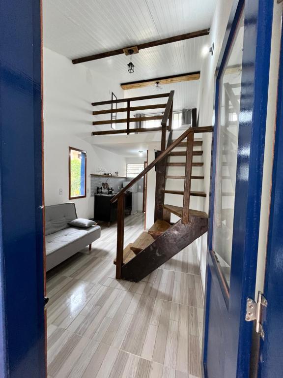 Una habitación con escalera y sala de estar. en Casinhas da toca, en Búzios