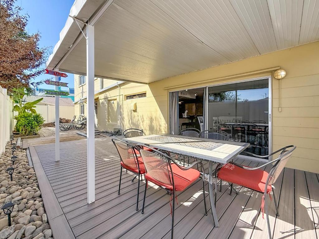 un patio avec une table et des chaises sur une terrasse dans l'établissement Waves 1, à St. Pete Beach