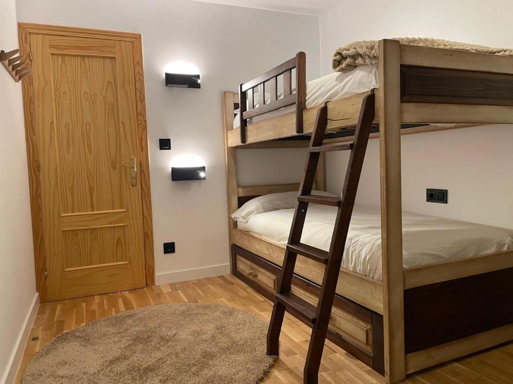 a bedroom with two bunk beds with a ladder at Casa Marali Ski & Bike Formigal in Formigal