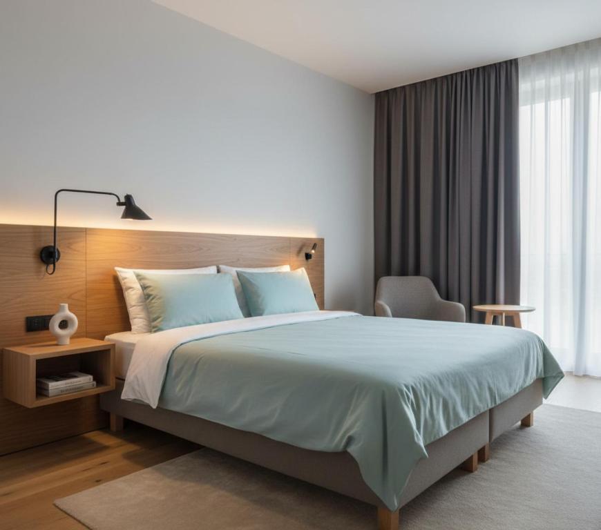 a bedroom with a large bed and a chair at Hotel Clina in Adana