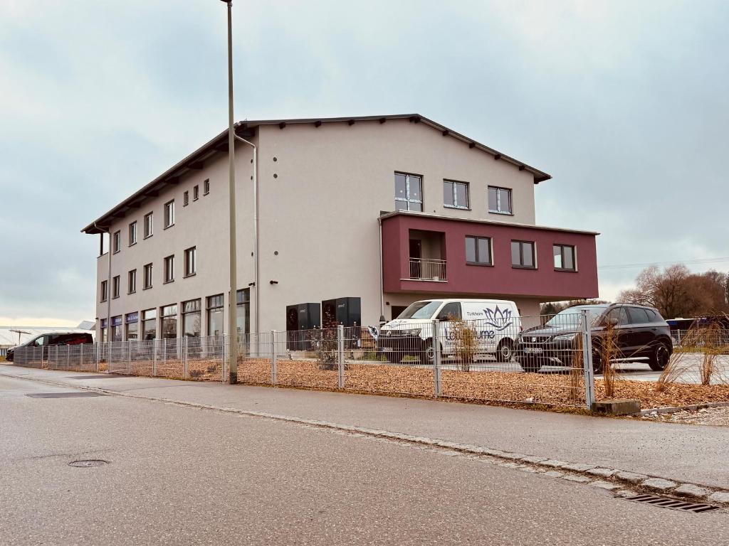 a building with two cars parked in front of it at PEN Smart Hotel in Türkheim