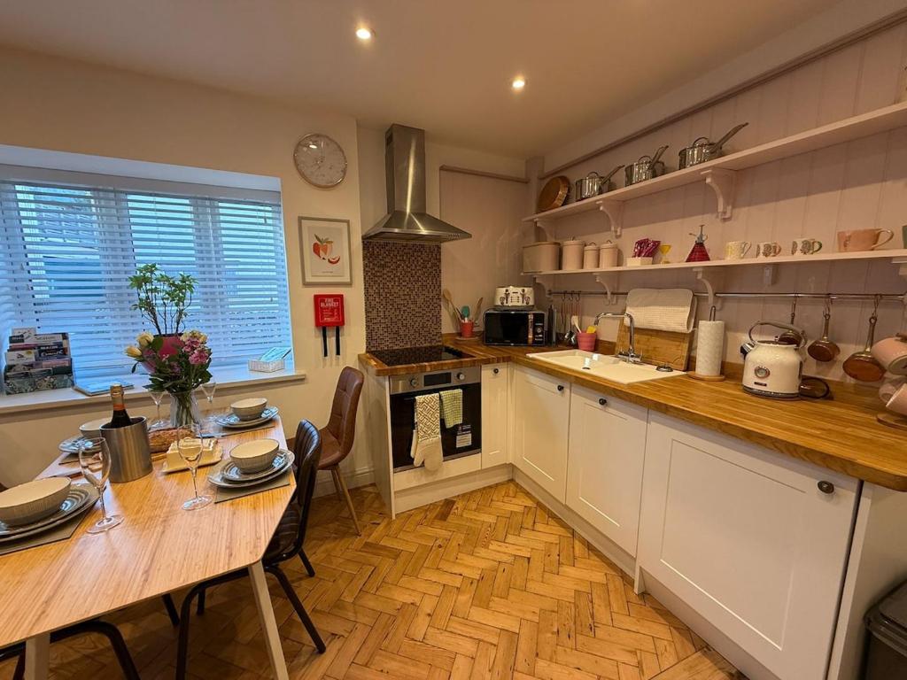 a kitchen with a wooden table and a wooden floor at Half Pint Cottage in Uplyme