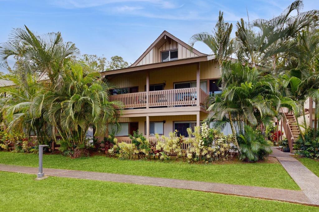 a large building with palm trees in front of it at SandPiper #116a in Princeville