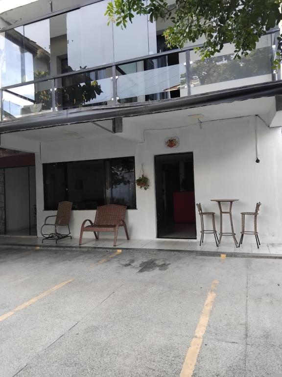サルバドールにあるPPousada 03 min da praia, Itapuaの横に椅子・テーブルを配した建物